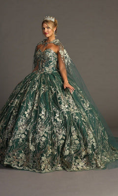A woman wearing the Quinceanera Dress CHF3079 By Chicas—a strapless green ballgown featuring metallic floral embroidery—paired with a crown and a matching embroidered cape, standing against a plain background.
