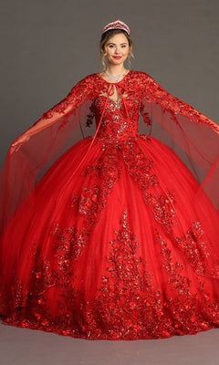 A woman wearing the Quinceanera Dress CHF3080 by Chicas in stunning red and gold poses with her arms out, showing off the gown’s 3D floral appliques, sheer cape, and sparkling tiara.