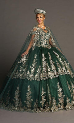 A woman wearing the Quinceanera Dress CHF3083 by Chicas—an ornate green ballgown with gold embroidery, a matching crown, and layers of glitter tulle—poses against a plain grey background.