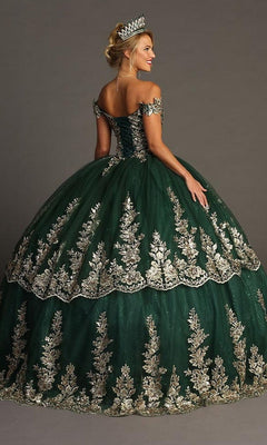 A woman poses with her back to the camera, wearing the Quinceanera Dress CHF3083 by Chicas—a green gown adorned with gold embroidered details and complemented by a tiara. She stands against a plain background.