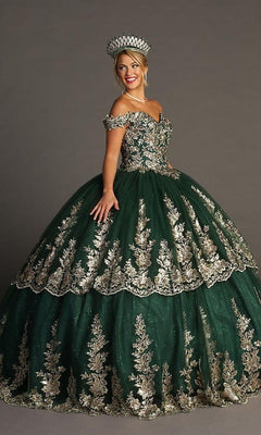 A woman stands and smiles against a plain gray background, wearing the Quinceanera Dress CHF3083 By Chicas—an off-the-shoulder, sweetheart neckline dark green gown adorned with gold embroidery and paired with a matching crown.