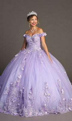 A woman wearing the Quinceanera Dress CHF3085 By Chicas—a light purple glitter tulle ballgown adorned with delicate floral appliques and paired with a tiara—stands against a plain background.