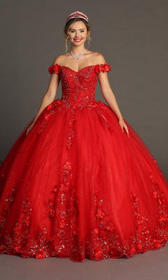 A woman wearing the red Quinceanera Dress CHF3085 by Chicas, featuring floral appliques and an off-the-shoulder design, paired with a sparkling tiara and necklace, stands against a plain gray background.
