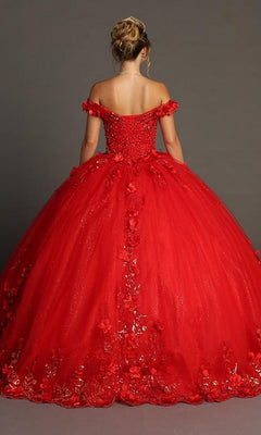 A woman stands with her back to the camera, displaying the off-the-shoulder, full-skirted Quinceanera Dress CHF3085 By Chicas—a red glitter tulle ballgown adorned with floral appliqués—set against a plain gray background.