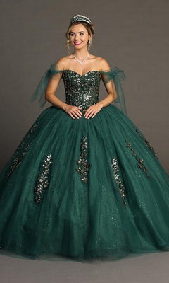 A woman stands against a plain background wearing the Quinceanera Dress CHF3086 By Chicas, a dark green off-the-shoulder gown adorned with silver embellishments and paired with a tiara, beautifully showcasing the elegance of its traditional voluminous ballgown skirt.