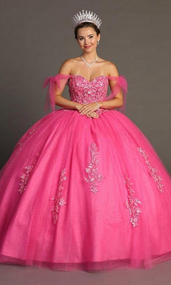 A woman stands against a plain background wearing the Quinceanera Dress CHF3086 by Chicas, a hot pink gown adorned with sparkling floral details, featuring an off-the-shoulder neckline and a voluminous ballgown skirt, complemented by a tiara and necklace.