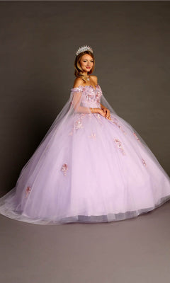 A woman wearing a sparkling tiara and the Quinceanera Dress CHF3095 By Chicas in lilac, beautifully adorned with intricate floral appliques and featuring an off-the-shoulder design, stands against a plain studio background.