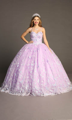 A young woman wearing the Quinceanera Dress CHF3097 By Chicas, featuring sparkly lilac glitter tulle and delicate butterfly appliques, paired with a silver tiara and red lipstick, stands against a plain gray background.
