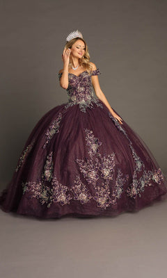 A woman wearing the Quinceanera Dress CHF3099 By Chicas—a dark purple, off-the-shoulder ball gown adorned with floral embroidery and paired with a crown—poses against a plain gray background, highlighting the elegance of its voluminous classic silhouette.