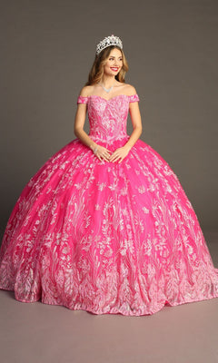 A woman wearing the Quinceanera Dress CHF3100 by Chicas—a pink, off-the-shoulder tulle ballgown adorned with white floral patterns—paired with a tiara and necklace, standing against a plain background.