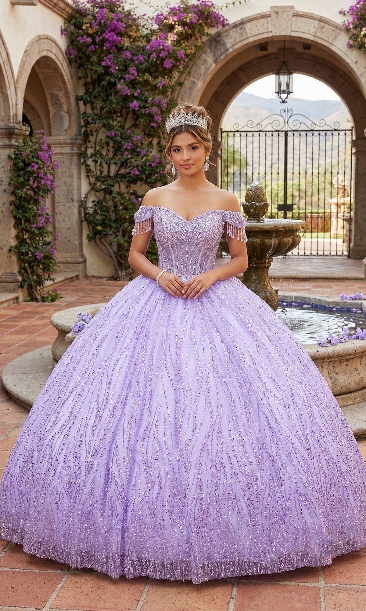 A young woman stands outdoors in front of a fountain, surrounded by stone arches and purple flowers, wearing the Quinceanera Dress CHF3116 By Chicas in lavender. The ornate gown features a corset bodice, voluminous ballgown skirt embellished with intricate beading, and is complemented by a sparkling tiara.