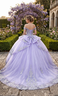 A woman in the Quinceanera Dress CHF3123 By Chicas, featuring lilac fabric and silver embroidery, stands in a garden beneath a wisteria-covered arch, facing away.