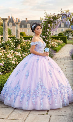 A young woman in the Quinceanera Dress CHF3124 By Chicas, featuring a Blue/Lilac-Multi color and 3D floral accents, stands in a formal garden holding a blue rose.