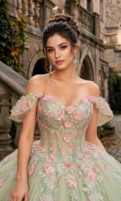 A woman wearing the Quinceanera Dress CHF3126 By Chicas, a pastel-green gown with delicate floral embroidery, stands outdoors beside a stone staircase and historic building.