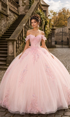 A woman stands outdoors in front of stone stairs, wearing the Quinceanera Dress CHF3130 By Chicas in blush, which features an off-the-shoulder corset-style bodice adorned with floral lace accents and a full tulle ballgown skirt.