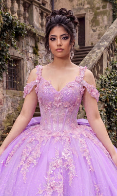 Wearing the Quinceanera Dress CHF3136 By Chicas, a woman stands outdoors in front of stone steps and ivy-covered walls, her elegant lavender ballgown adorned with delicate 3D floral appliques flowing gracefully around her.