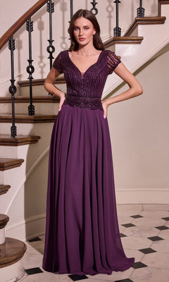 A woman wearing the Long Flowy Navy Formal Dress: Ladivine CL07, featuring short sleeves, a v-neckline, and an embellished bodice, stands in front of a curved staircase.