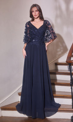 A woman wears the Ladivine CL10 Long Formal Dress in navy, featuring a floor-length skirt, lace-embroidered bodice, and lace sleeves. She stands on a staircase facing forward with hands in the dress pockets.