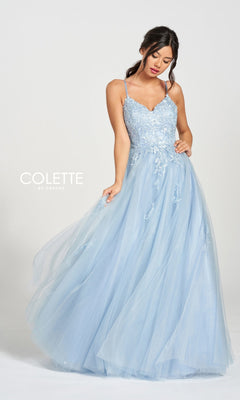 A woman in the Long Prom Dress CL12212 by Colette—light blue, floor-length tulle with thin straps and floral embroidery—stands against a plain background, with the Colette by Daphne logo visible on the left.