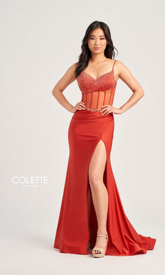 A woman poses against a plain background in the Sheer-Bodice Long Collette Prom Dress CL5104— a fitted, floor-length red gown featuring a beaded v-neckline, spaghetti straps, sheer midriff panels, and a thigh-high slit with platform heels.