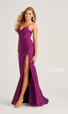 A woman stands against a plain background wearing the Corset-Bodice Long Colette Tight Prom Dress CL5111—a sleeveless, magenta, floor-length gown with spaghetti straps and a thigh-high slit.
