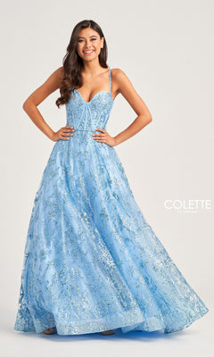 A woman smiles against a light background in the Colette Glitter-Tulle Long Prom Ball Gown CL5117—a light blue, floor-length A-line dress with sparkling floral embroidery and a corset-style open back.
