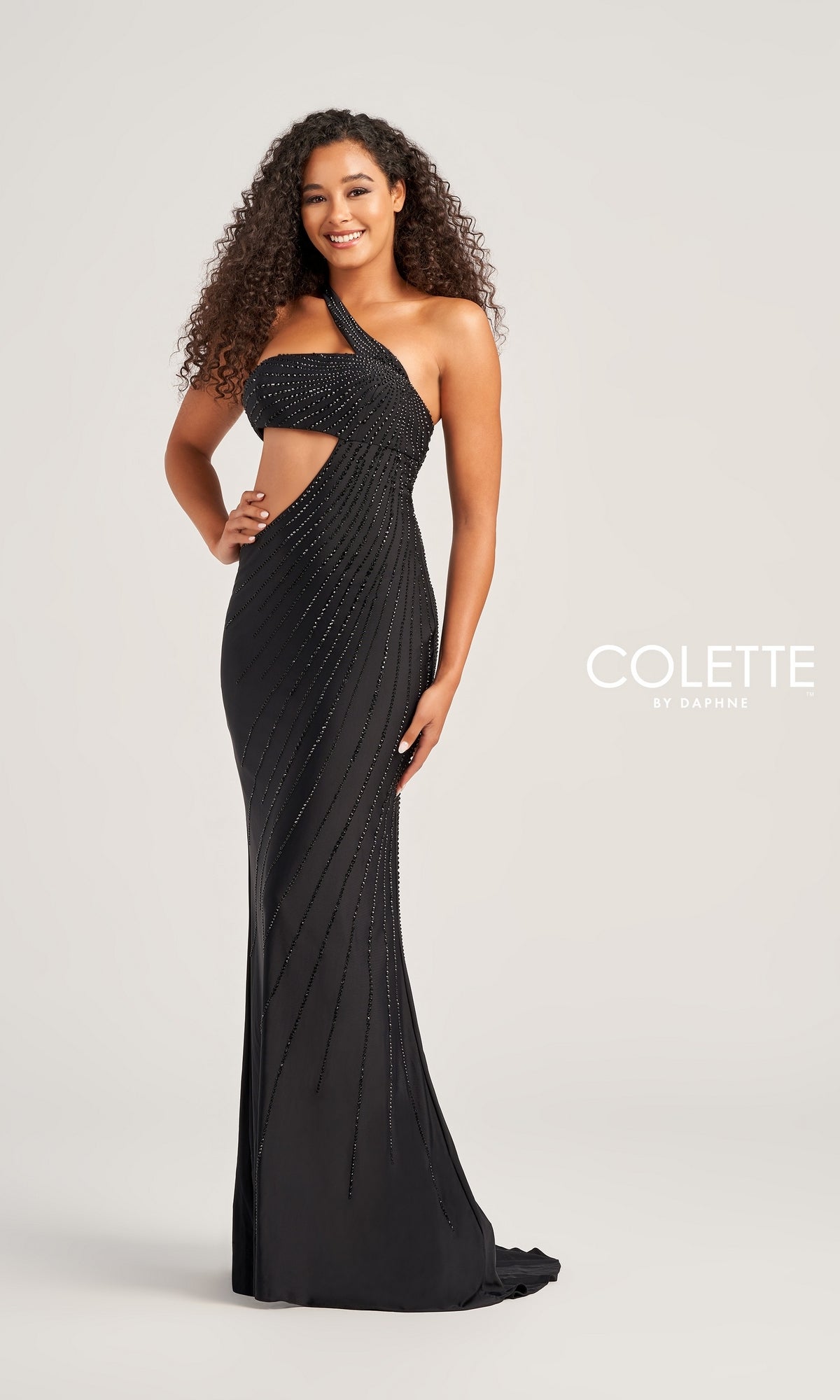 A woman poses against a plain light background in the Colette One-Shoulder Sleek Long Prom Dress CL5139, featuring a fitted silhouette, cutout detailing, and sparkling beaded accents for an elegant formal look.