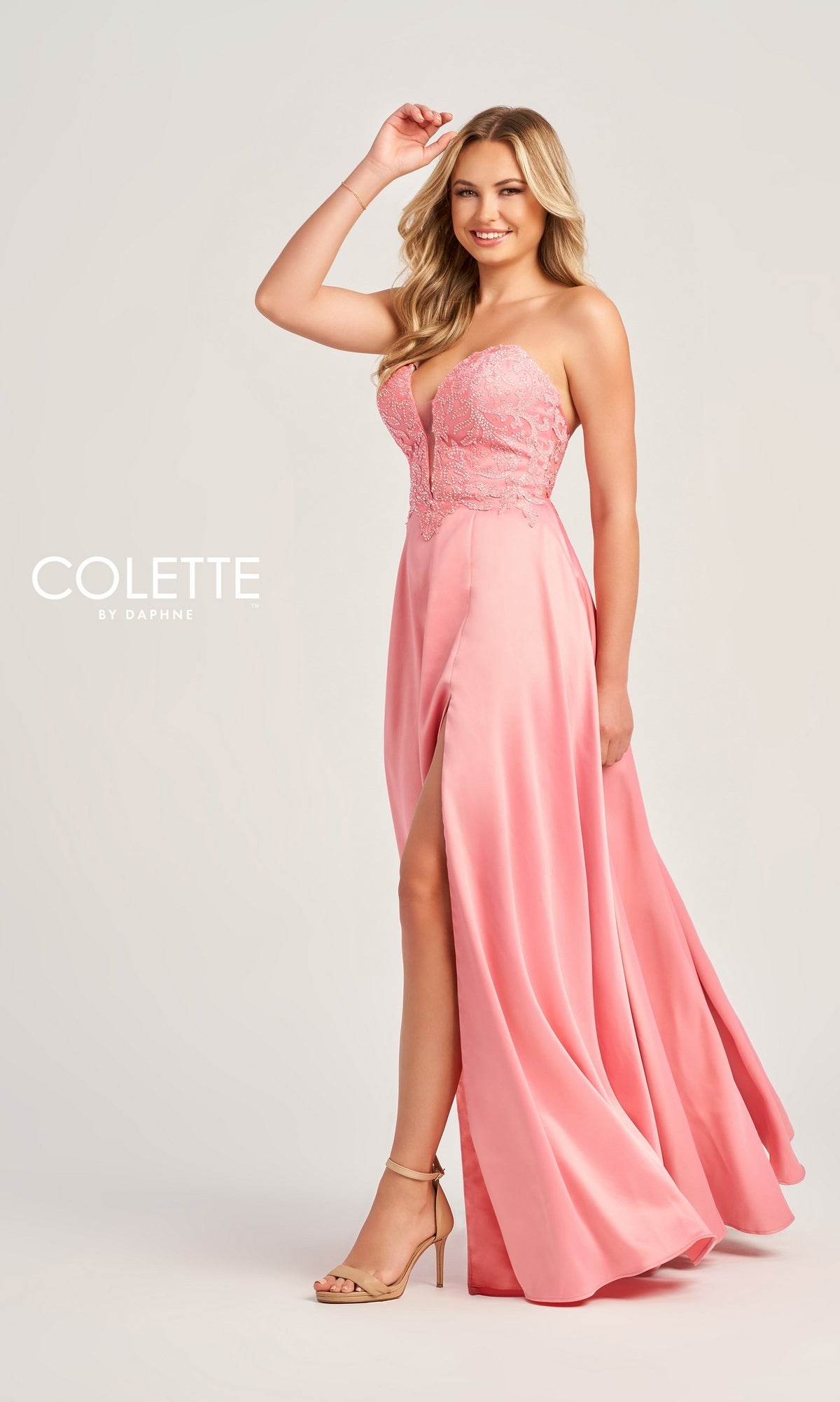 A woman models the Colette Strapless Long Designer Prom Dress CL5142, a pink gown with a thigh-high slit and nude heels, against a plain light background. The text 