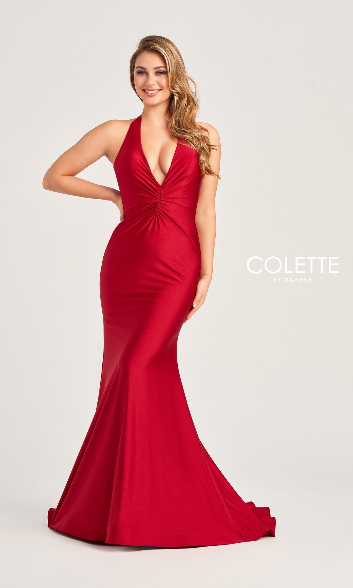A woman models the Colette Front-Knot Long Halter Prom Dress CL5199, a figure-flattering red mermaid gown made from stretch spandex jersey, against a plain background.