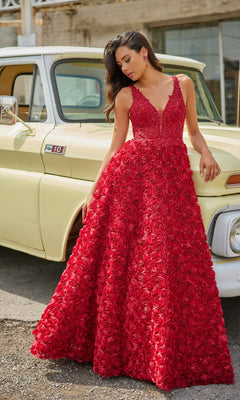 A woman wearing the Colette Long Red Rosette Prom Dress CL5251 stands beside a vintage yellow pickup truck on a sunny day.