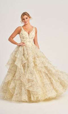 A woman stands against a light background wearing the Colette Tiered Long Print Prom Ball Gown CL5273, featuring a sleeveless V-neck, floral print, and layered ruffled tulle skirt.
