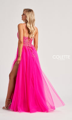 A woman wearing the Colette CL8030 long prom dress in bright pink, featuring a sequined bodice, spaghetti straps, high slit, and decorative beading, stands against a plain light background.