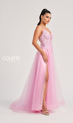 Woman in a pink lace and tulle A-line Long Prom Dress: Colette CL8100 with a high slit, standing in heels against a plain background. Delicate lace embroidery enhances the elegant look. The "Colette by Daphne" logo appears on the left.