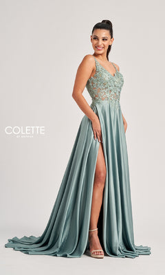 A woman stands smiling in the Colette CL8160 long prom dress, an A-line sage green gown with a lace bodice, thin straps, rhinestone details, and a high side slit.