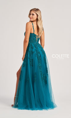 A woman models the Colette CL8220 long prom dress in teal, featuring floral embroidery and a lace-up back, standing against a plain light background.