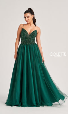A woman stands against a plain background in the Colette CL8250 Long Prom Dress, featuring a dark green sequin bodice with thin straps and a full beaded tulle skirt for an elegant, floor-length look.