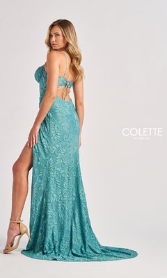 A woman in the Floral-Lace Long Corset Prom Dress: Colette CL8405, a teal gown with a high side slit, open back, and subtle train, poses in profile against a plain light background.