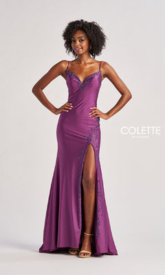 A woman in the Colette CL8485 long prom dress, featuring a sleeveless purple design with a thigh-high slit and corset bodice, stands against a plain light background.