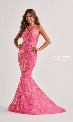 A woman poses against a plain light background wearing the Colette CL8495, a long pink mermaid prom dress with gold floral embroidery and an elegant halter neckline.