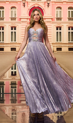 A woman in the Colette CL8520 strapless pleated long prom dress, featuring shimmery lavender fabric and sparkling rhinestone bows, stands before a pink and beige building with arched windows, holding out one side of her gown.