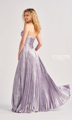 A woman in the Colette CL8520 Strapless Pleated Long Prom Dress poses, looking over her shoulder. This elegant lavender a-line gown features rhinestone bows and displays the "Colette by Daphne" logo.
