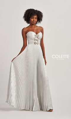 A woman wears the Strapless Pleated Long Prom Dress Colette CL8520 with rhinestone bow accents at the waist, standing against a plain background. “COLETTE by Daphne” is displayed on the right.