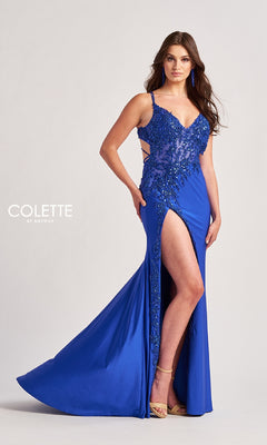 A woman in the Colette CL8535 long prom dress—royal blue, v-neck, spaghetti straps, sequin details, thigh-high slit—and beige heels stands against a plain background.