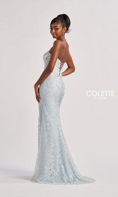 A woman stands in a studio wearing the Colette CL8595 Long Prom Dress—a light blue, strapless, floor-length lace gown with a lace-up back. The "Colette by Daphne" logo is visible.