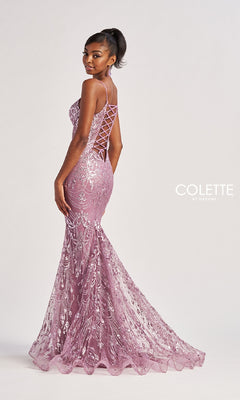 A woman poses against a plain light background in the Colette CL8630 long prom dress—a fitted, floor-length purple gown with embroidery, spaghetti straps, and a strappy open back.