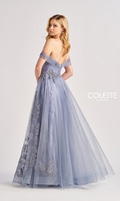 A woman in a dusty blue Long Prom Dress: Colette CL8640 with a sweetheart neckline, silver floral embellishments, fitted bodice, and tulle skirt stands facing away. The "COLETTE by Daphne" logo appears at right.