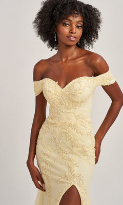 A woman models the Colette CL8645, an off-the-shoulder long prom dress in pale yellow with floral embroidery, beading, a thigh-high slit, and mermaid silhouette against a plain background.