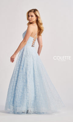A woman wears the Long Prom Dress: Colette CL8650, a light blue embroidered floor-length A-line gown with a lace-up back, standing against a plain white background. The "Colette by Daphne" logo is visible.