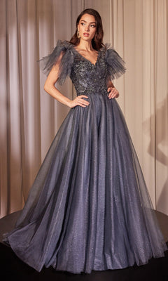 A woman wears the Flutter-Sleeve Blue Prom Ball Gown: Ladivine CM359, featuring a sequin-lace bodice, tulle skirt, and sheer flutter sleeves, standing against a light curtain background.