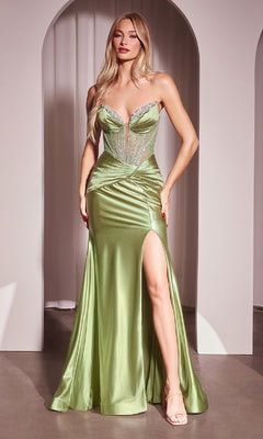 A woman wears the Strapless Long Corset Prom Dress: CLCM368, a shiny light green gown with a sweetheart neckline, high slit, beaded accents, sheer bodice, and mermaid skirt, posed by a minimalist archway.